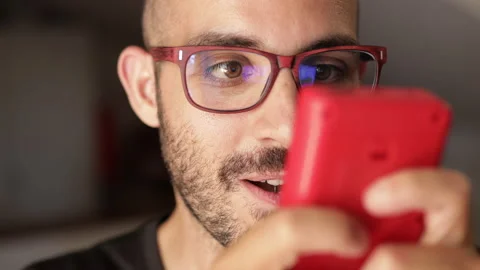 Nerd plays with a little red retro video game. Male game player. Portrait shot Video stock 136905948