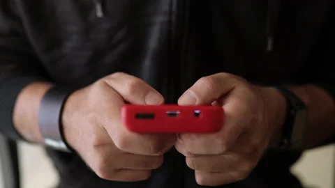 Nerd plays with a little red retro video game. Male game player. Hands close up Video stock 136973391