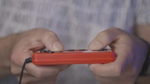 Nerd plays with red retro video game. Male game player. Hands close up Stock Footage 154209046
