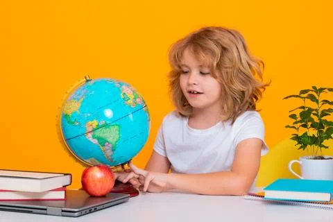 Nerd pupil boy from elementary school with book isolated on yellow studio Stock Photos
