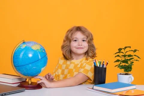 Nerd pupil. Clever child from elementary school looking at globe during Stock Photos