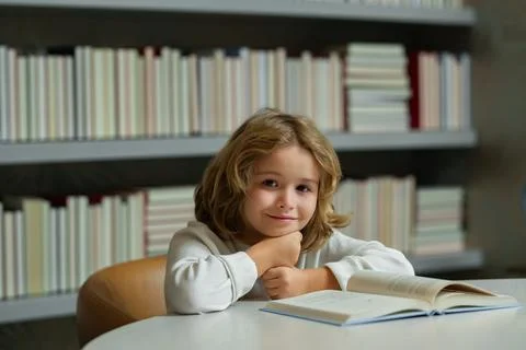 Nerd pupil. Schoolboy doing homework on desk in school library. Child studying Foto stock