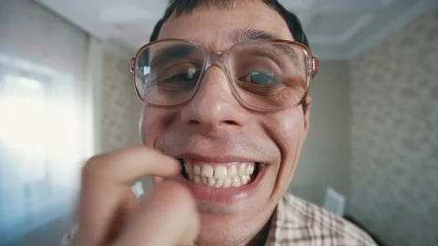 Nerd shows his teeth to the camera Video stock 165588626