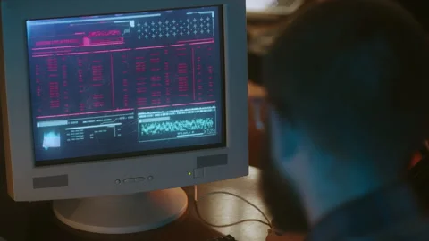 Nerdy guy in glasses hacking into computer, stealing secret data, retrofuturism Stock Footage 213990479