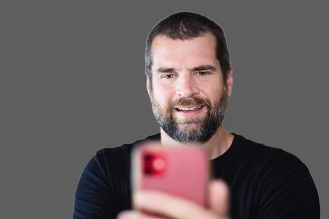 Nerdy Man Reading Interesting Article on Phone Stock Photos