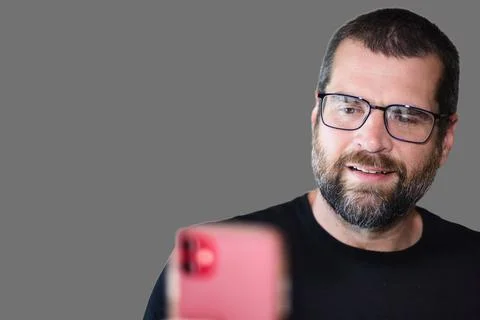Nerdy Man Reading Interesting Article on Phone Stock Photos
