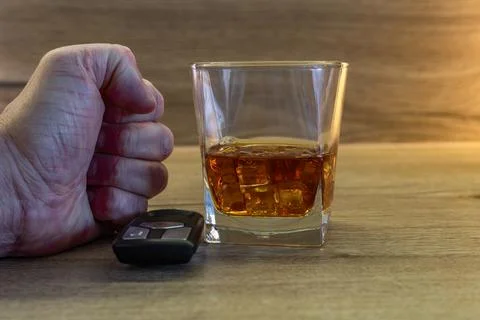 A nervous driver drinks alcohol at a bar, the clenched fists of a man bangi.. Stock Photos