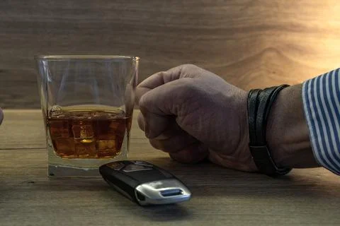 A nervous driver drinks alcohol at a bar, the clenched fists of a man bangi.. Stock Photos
