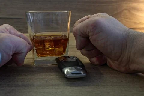 A nervous driver drinks alcohol at a bar, the clenched fists of a man bangi.. Stock Photos