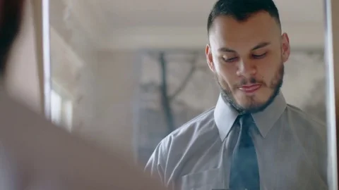 Nervous hispanic man practicing sales pitch in mirror as he gets ready Stock Footage 84484408