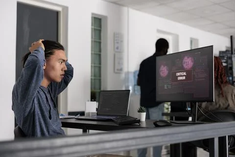 Nervous it programmer having security breach alert on computer display Stockfoto's