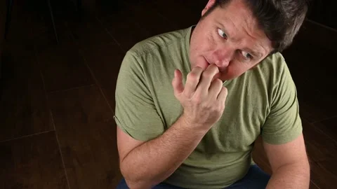 A nervous looking man bites his nails in anticipation of something bad Stock Footage 229896986