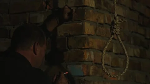 A nervous man on the background of a rope with a noose for suicide. Stock Footage 343733683