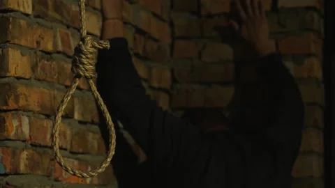 A nervous man on the background of a rope with a noose for suicide. Stock Footage 343733706