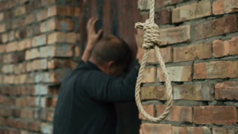 A nervous man on the background of a rope with a noose for suicide. Stock Footage 343734264