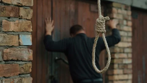 A nervous man on the background of a rope with a noose for suicide. Stock Footage 343734295