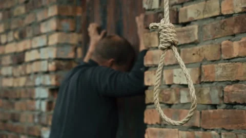 A nervous man on the background of a rope with a noose for suicide. Stock Footage 343734318