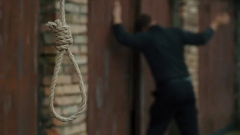 A nervous man on the background of a rope with a noose for suicide. Stock Footage 343734346