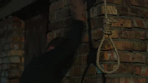 A nervous man on the background of a rope with a noose for suicide. Stock Footage 343734401