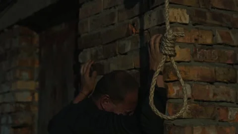 A nervous man on the background of a rope with a noose for suicide. Stock Footage 343734443