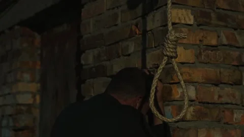 A nervous man on the background of a rope with a noose for suicide. Stock Footage 343734456