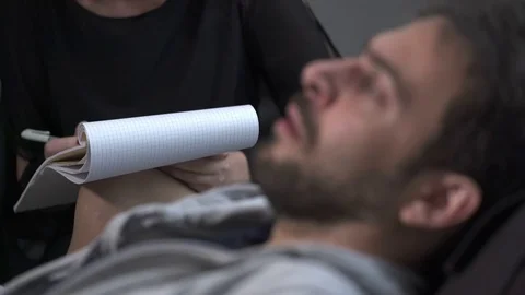 Nervous man lying on the couch talking to the psychiatrist Stock Footage 71006821