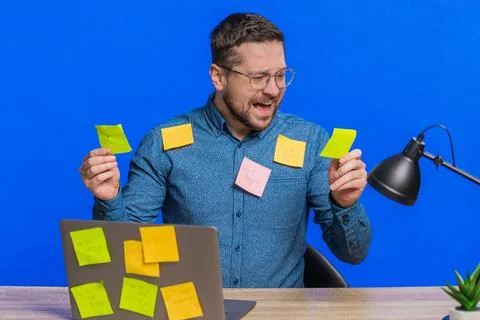 Nervous man with pasted sticker notes use laptop having concentration problem Stock Photos