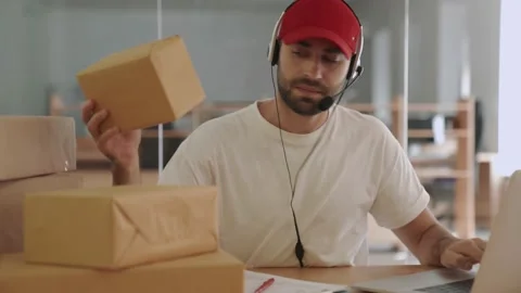 Nervous post manager using laptop computer and holding parcel boxes Stock Footage 153843638
