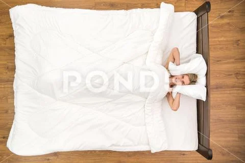 The nervous woman lay on the bed and scream. View from above Stock Photos