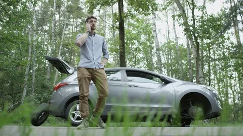 Nervous Young Man Talking on the Phone Near his Car Stock Footage 79824032