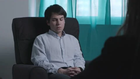 Nervous young man talks with difficulty with the psychologist Stock Footage 197785677