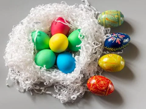 Nest with colored Easter eggs pn gray background. Stock Photos
