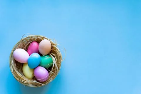 Nest of coloured Easter eggs on blue background Stock-Fotos