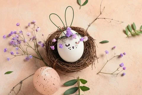 Nest of creative Easter eggs with flowers and leaves on grunge pink backgroun Stock Photos