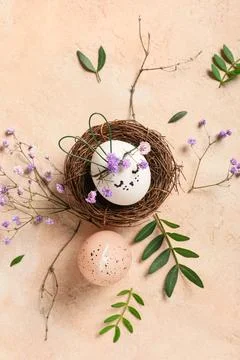 Nest of creative Easter eggs with flowers and leaves on grunge pink backgroun Stock Photos