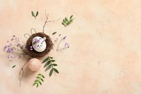 Nest of creative Easter eggs with flowers and leaves on grunge pink backgroun Stock Photos
