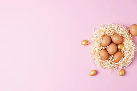 Nest with easter eggs with flowers on pink background. Flat lay, copy space Stock Photos