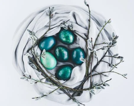 Nest of fabric with Easter eggs in turquoise and gold decorated with pussy Stock Photos