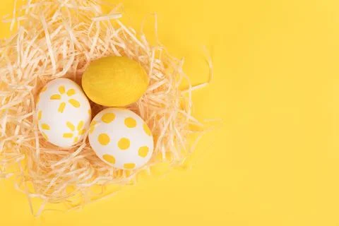 Nest with painted easter eggs on yellow background Stock Photos