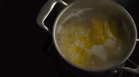Nest pasta boiling in a pot on electric stove Stock Footage