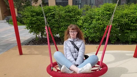 Nest Swing. Front view of young woman is swinging on a swing. Red Nest Swing 스톡 동영상 131436674