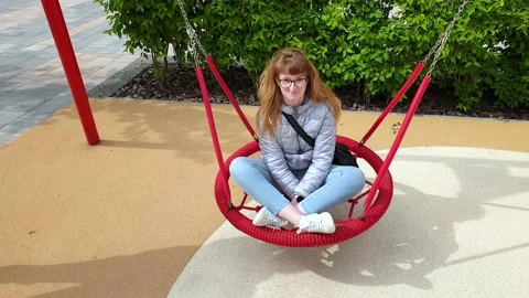 Nest Swing. Top view of young woman is swinging on a swing. Red Nest Swing Stock-Footage 132194333