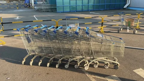 Nesting Empty Supermarket Shopping Carts on the asphalt parking at sunset Stock Footage 339639904