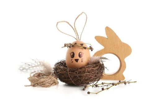 Nests with creative Easter eggs, wooden rabbit and branches isolated on white Stock Photos