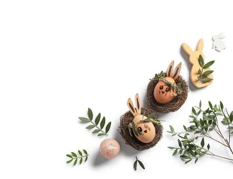 Nests of cute painted Easter eggs with drawn face, decorations and leaves on  Stock Photos