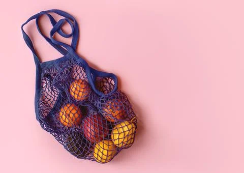 Net bag with fruit on bright background. Zero waste and ecology conservation Foto stock