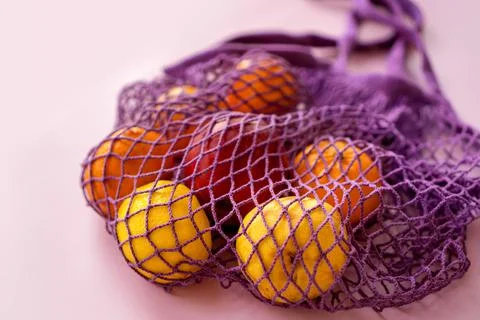 Net bag with fruit on bright background. Zero waste and ecology conservation Stock Photos