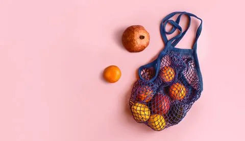 Net bag with fruit on bright background. Zero waste and ecology conservation Stock Photos