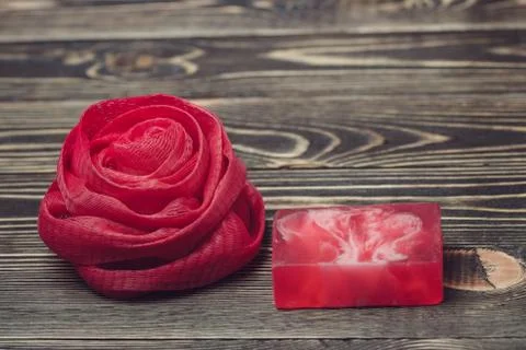 Net bath sponge and soap red color on wooden background Stock Photos