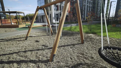 Net hammock and swings on empty sunny playground in yard Vídeo Stock 330284246